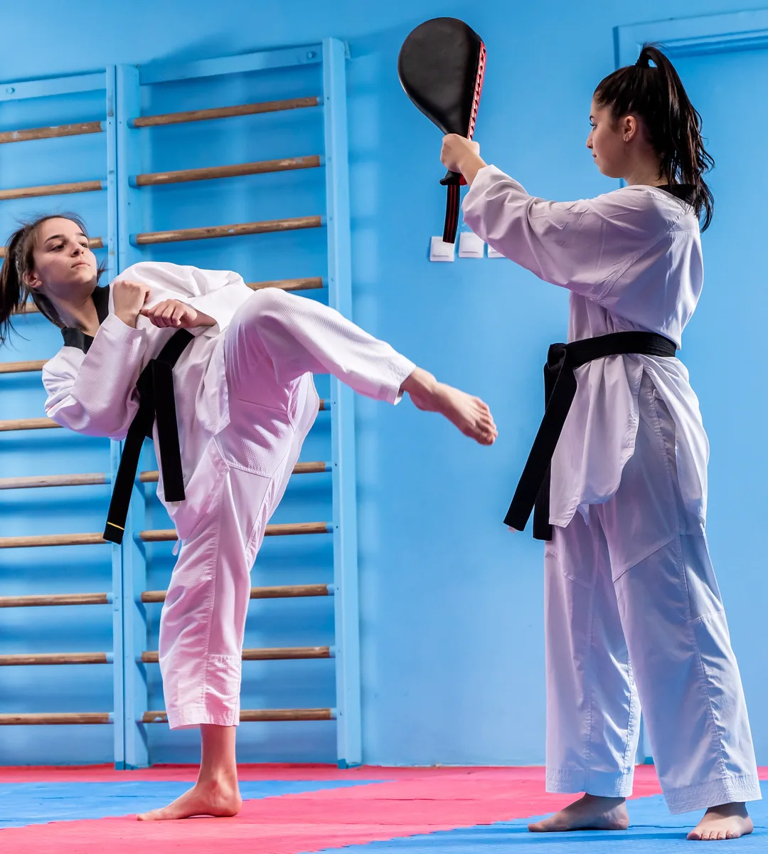 A woman throws a high roundhouse kick